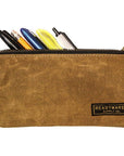 Tan waxed canvas zip pouch holding pens and pencils on a white background