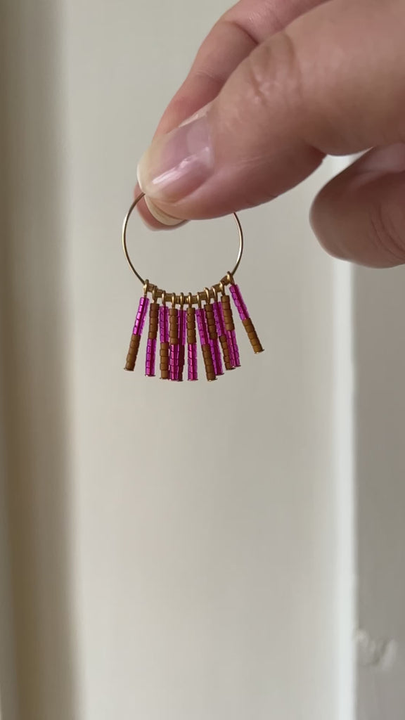 Crafted from durable 14k gold-filled or sterling silver and meticulously adorned with hand-beaded Japanese glass beads, the Kaleid Fringe Hoops are the ultimate expression of modern personality. These statement earrings don't just complement your look; they become the focal point of your ensemble.