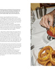 Book spread on RingSide in Portland, with hands dipping onion rings into sauce beside a martini