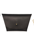 Black leather clutch with wrist strap and adjustable crossbody strap on white