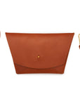 Tan leather clutch with wrist strap and adjustable crossbody strap on white